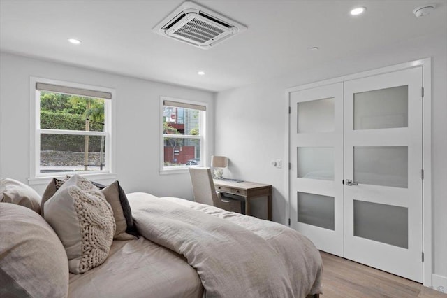 bedroom with light hardwood / wood-style floors and a closet