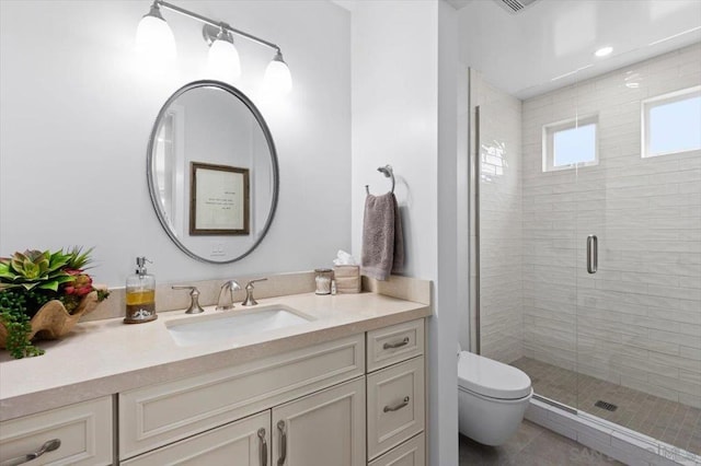 bathroom featuring vanity, a shower with shower door, tile patterned floors, and toilet