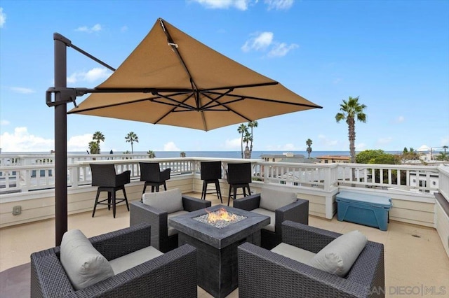 view of patio featuring a water view and an outdoor living space with a fire pit