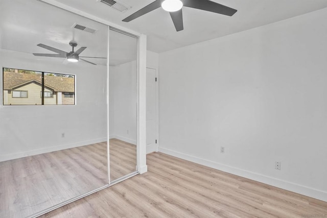 unfurnished bedroom featuring light hardwood / wood-style floors, a closet, and ceiling fan