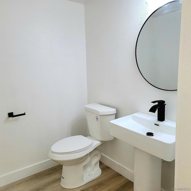 bathroom with hardwood / wood-style flooring and toilet