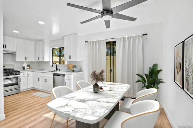 dining area with sink, ceiling fan, and light hardwood / wood-style flooring