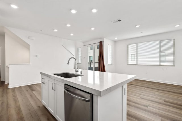 kitchen featuring sink, dishwasher, a kitchen island with sink, light hardwood / wood-style floors, and white cabinets