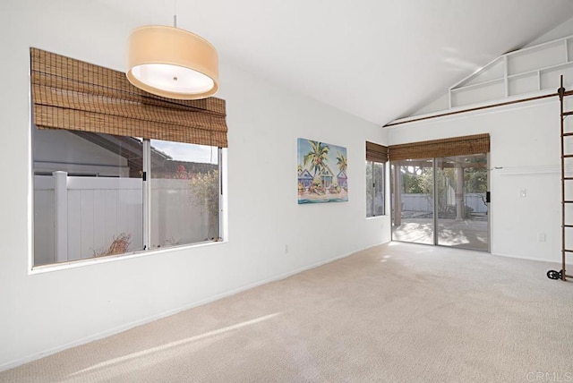 spare room featuring carpet floors and high vaulted ceiling