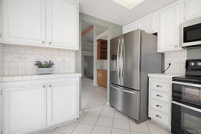 kitchen featuring white cabinetry, tile counters, and stainless steel appliances