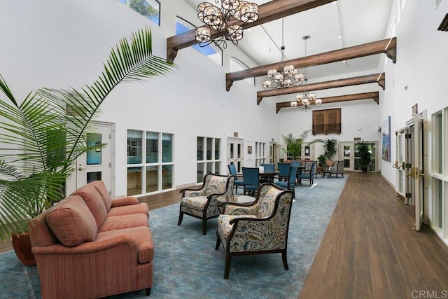 living room with dark wood-type flooring, a towering ceiling, beam ceiling, and a notable chandelier