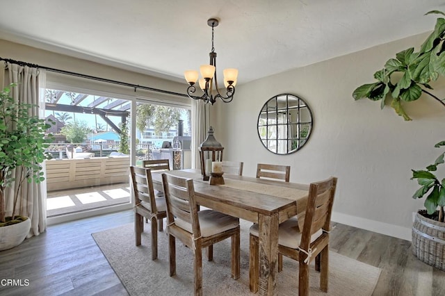 dining room with baseboards, a notable chandelier, and light wood-style floors