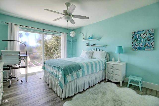 bedroom featuring access to outside, baseboards, a ceiling fan, and wood finished floors