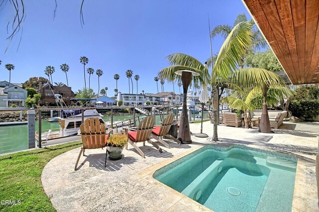 view of pool featuring a dock, a residential view, and a patio area