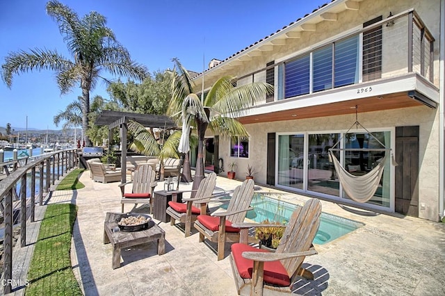 view of patio with an outdoor pool, an outdoor living space with a fire pit, a balcony, and a pergola