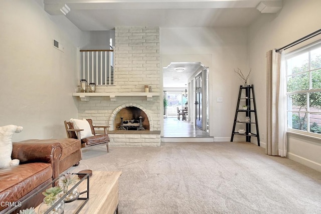 living area with a fireplace, carpet flooring, visible vents, and baseboards