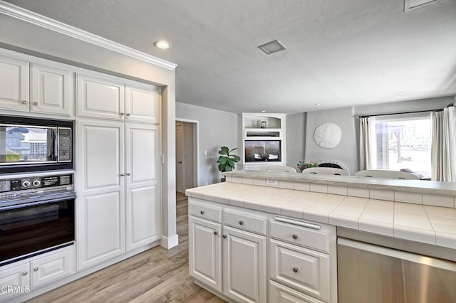 kitchen with white cabinetry, black appliances, tile countertops, and light wood finished floors