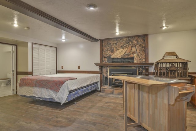 bedroom with a fireplace and dark hardwood / wood-style floors