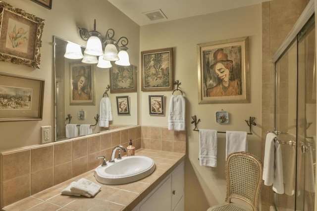 bathroom with vanity, tasteful backsplash, and an inviting chandelier