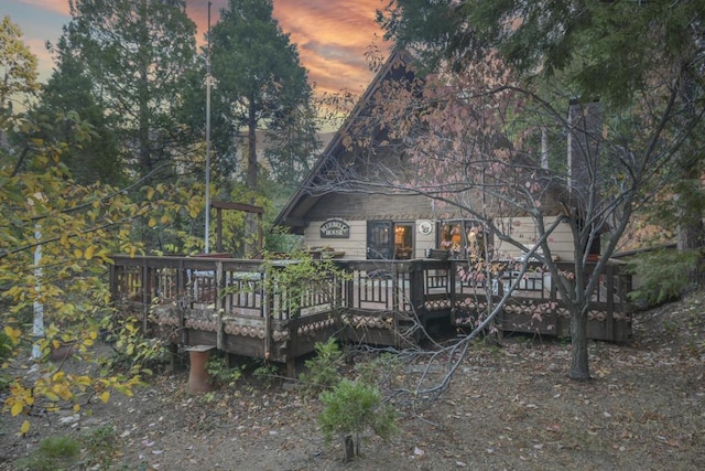 back house at dusk with a deck