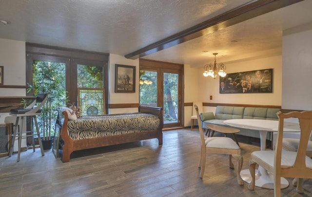 bedroom with hardwood / wood-style flooring, access to exterior, a notable chandelier, a textured ceiling, and beamed ceiling