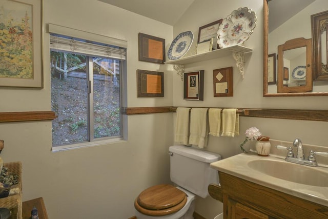 bathroom with lofted ceiling, vanity, and toilet