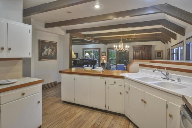 kitchen featuring sink, vaulted ceiling with beams, decorative light fixtures, light hardwood / wood-style floors, and white cabinets