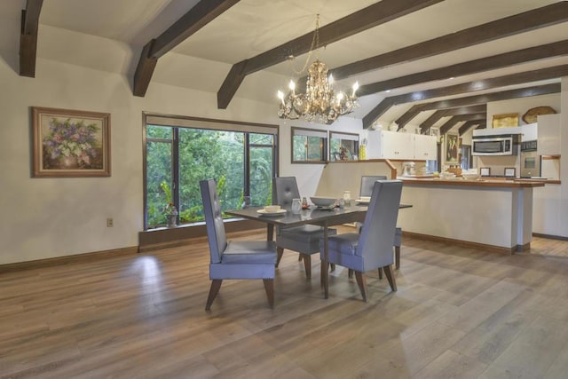 dining room featuring hardwood / wood-style flooring, a notable chandelier, and lofted ceiling with beams