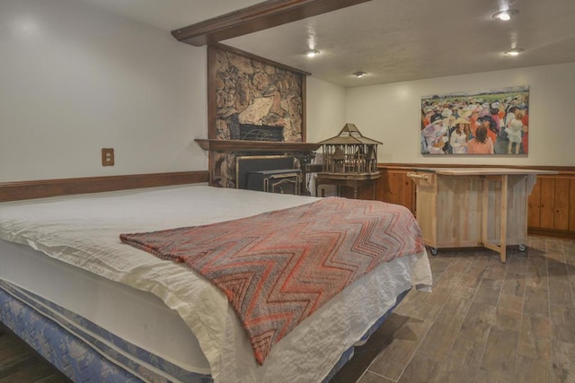 bedroom featuring a fireplace and dark hardwood / wood-style floors