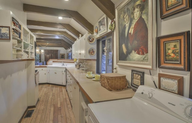 clothes washing area with sink, washer / dryer, light hardwood / wood-style flooring, and a chandelier