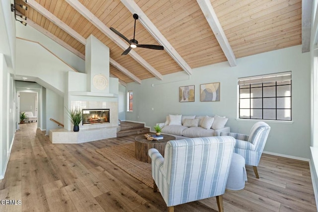 living room with wood ceiling, high vaulted ceiling, a fireplace, beamed ceiling, and light wood-type flooring