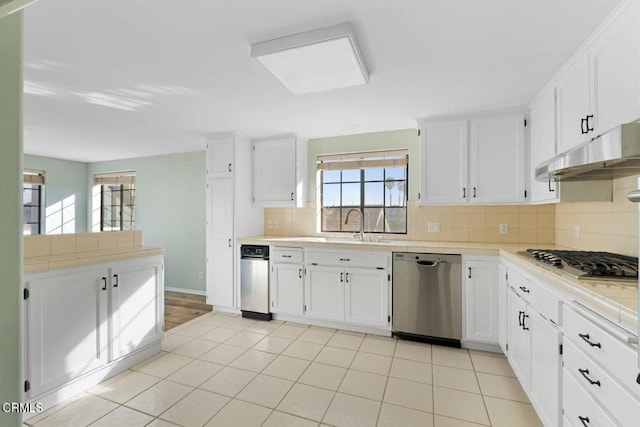 kitchen with white cabinetry, appliances with stainless steel finishes, light tile patterned flooring, and backsplash