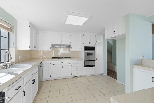 kitchen featuring white cabinetry, sink, decorative backsplash, and tile countertops