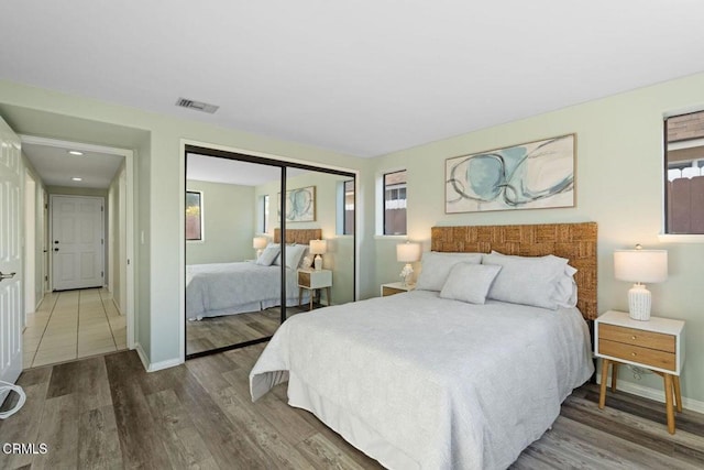 bedroom with hardwood / wood-style flooring, multiple windows, and a closet