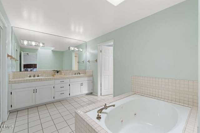 bathroom with tile patterned floors, vanity, and tiled bath