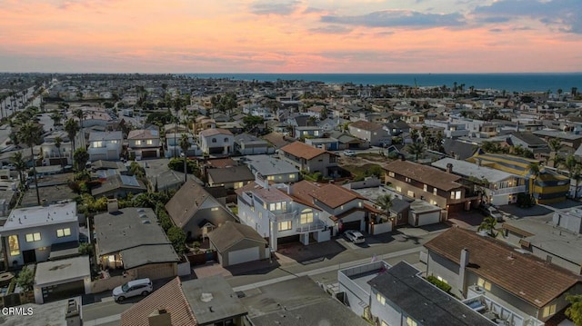 aerial view at dusk featuring a water view