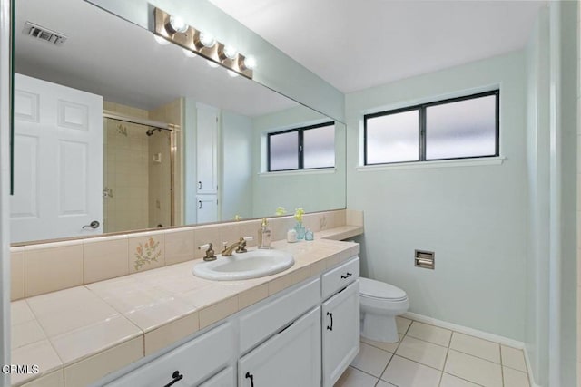 bathroom featuring vanity, toilet, a shower with shower door, and tile patterned flooring