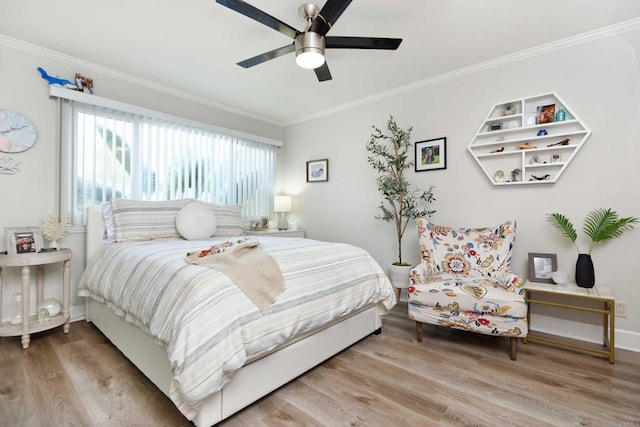 bedroom with hardwood / wood-style flooring, ornamental molding, and ceiling fan