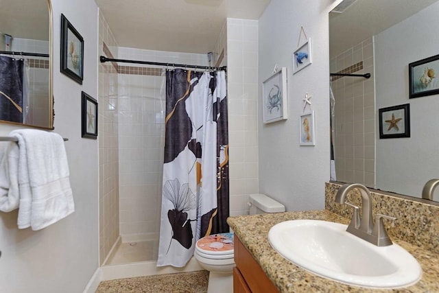 bathroom with vanity, curtained shower, and toilet