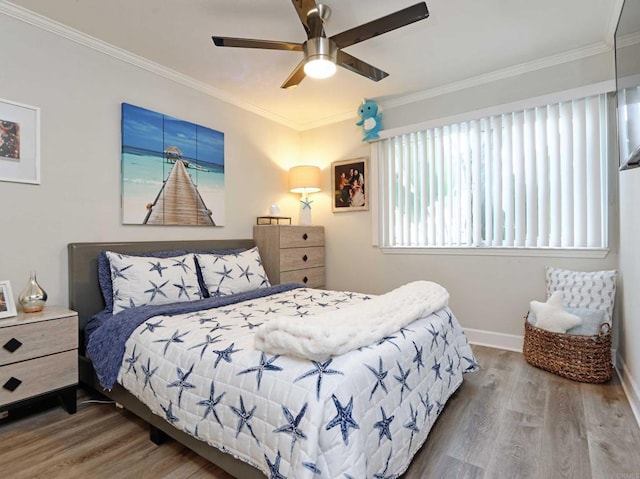 bedroom featuring hardwood / wood-style floors, ornamental molding, and ceiling fan