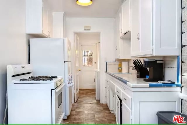 kitchen featuring sink, gas range gas stove, and white cabinets