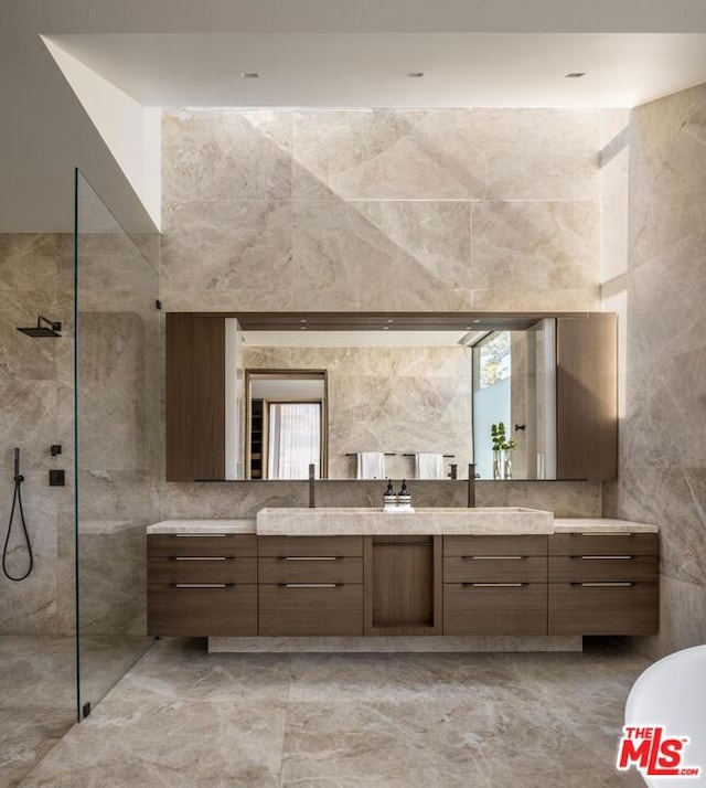 bathroom with vanity, a wealth of natural light, tile walls, and a tile shower