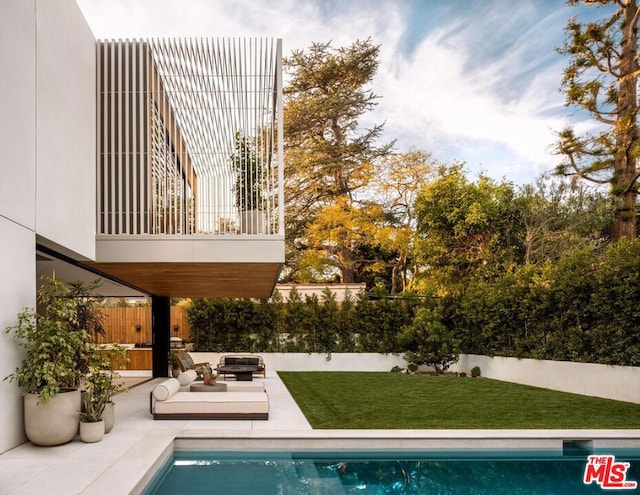 view of swimming pool featuring a lawn and a patio area