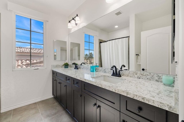 bathroom featuring tile patterned flooring, vanity, and walk in shower