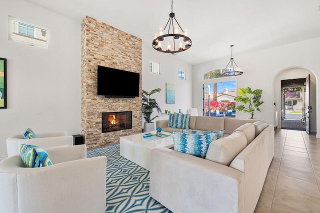 tiled living room with a notable chandelier and a fireplace