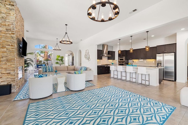 living room with sink, a chandelier, and light tile patterned flooring