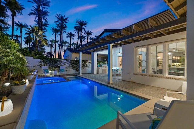 pool at dusk featuring a patio and a pergola