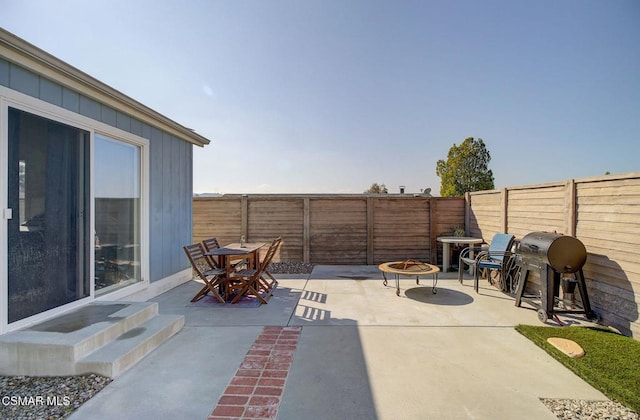 view of patio with area for grilling and an outdoor fire pit