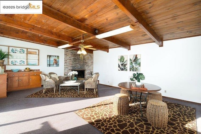 interior space with wood ceiling, ceiling fan, a fireplace, and beamed ceiling