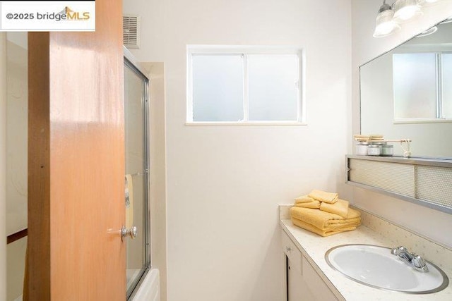 bathroom featuring vanity and enclosed tub / shower combo