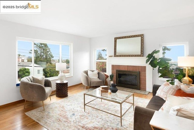 living room with a brick fireplace and light hardwood / wood-style floors