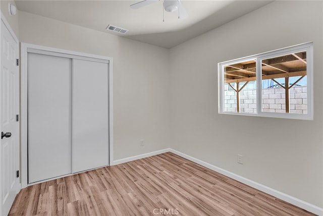 unfurnished bedroom with ceiling fan, light hardwood / wood-style floors, and a closet