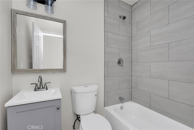 full bathroom featuring tiled shower / bath combo, vanity, and toilet