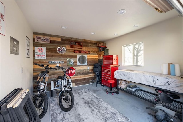 interior space featuring wooden walls, concrete flooring, and a workshop area