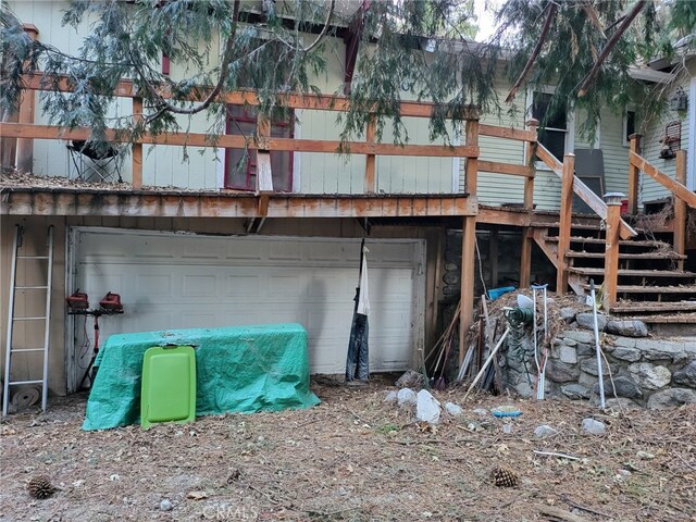 back of house with an attached garage and stairs